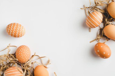 Mutlu Paskalyalar. Beyaz arka planda zarif Paskalya yumurtaları çerçevesi. Düz konum, üst görünüm, kopyalama alanı.
