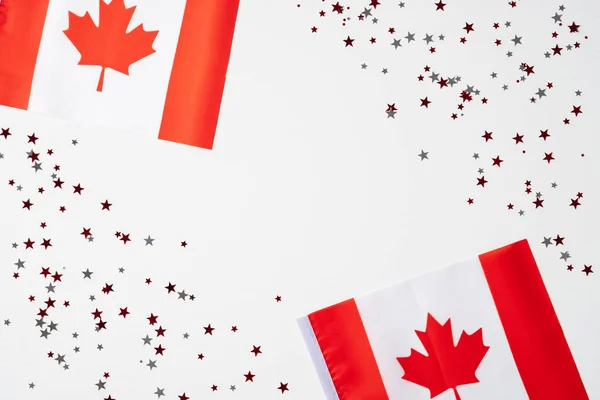 Happy Canada Day concept. National flags of Canada and confetti on white background. Canada Independence Day greeting card template.
