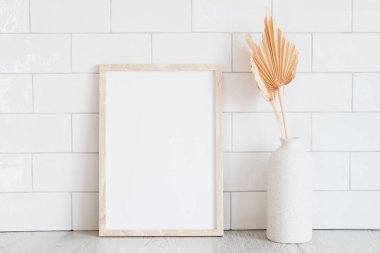 Ahşap dikey çerçeve modeli ve beyaz kiremitlerin arkasındaki vazoda kurumuş çiçekler. İskandinav iç mimarisi, kızlık zarı, rahat yaşam tarzı.