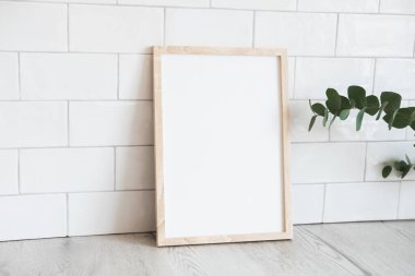 Portre beyaz resim çerçeve modeli ve okaliptüs. Arka planda tuğla kiremitler var. İskandinav, İskandinav tarzı.