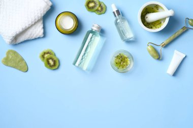 Natural organic SPA cosmetic products set with kiwi fruit. Top view herbal skincare beauty products on blue background. Banner mockup for beauty salon. Flat lay minimalist style