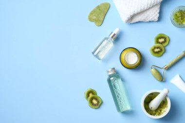 Natural organic SPA cosmetic products set with sliced kiwi fruit. Top view herbal skincare beauty products on blue background. Banner mockup for beauty salon