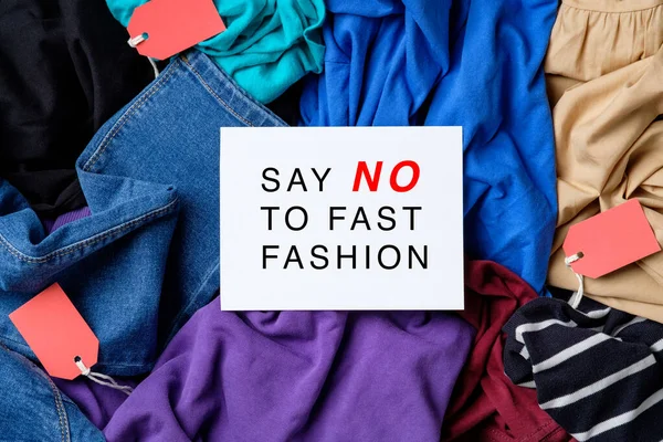 Řekni Fast Fashion Papírové Kartě Nad Hromadou Oblečení Fast Fashion — Stock fotografie