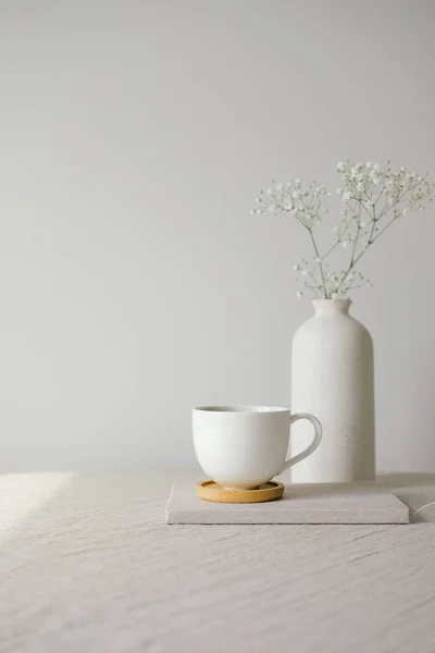 Šálek Kávy Vázy Gypsophila Květy Stole Plátnem Ubrus Bílá Zeď — Stock fotografie