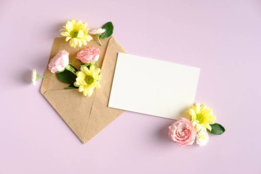 Open mail envelope with flowers and blank paper card on pink background. Romantic, Love letter concept.