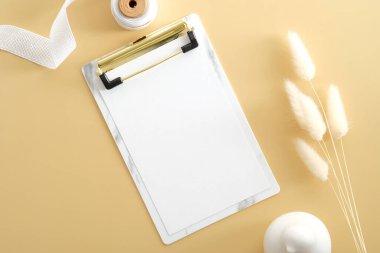 Bej masa üzerinde kurumuş çiçeklerle pano modeli. Zarif kadın çalışma alanı, ofis masası. Düz konum, üst görünüm, kopyalama alanı.