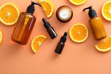 Citrus kozmetik seti C vitamini ve arka planda portakal dilimleri. Düz yatış, üst görünüm.