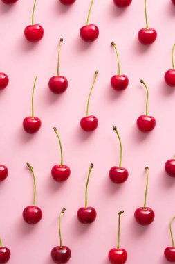 Pembe arka planda kiraz deseni. Düz yatıyordu, üst manzara Masada kırmızı olgun böğürtlenler.