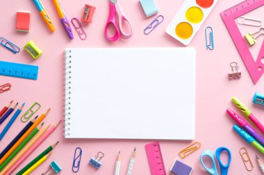 Okul kırtasiyesi ve pembe arka planda bir defter. Okulun yaratıcı planına dönelim. Üst görünüm.