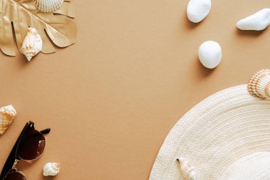 Yaz düz kompozisyon, staw har, güneş gözlüğü, kumlu renk arka planda deniz kabukları. Üst görünüm, genel görünüm.