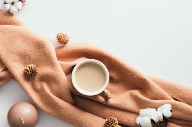 Flat lay plaid, cup of coffee, candle, pine cones, cotton on white desk. Hygge, autumn cozy mood, comfort concept. Flat lay, top view