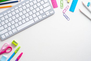 Düz yatay okul gereçleri ve beyaz arka planda bilgisayar klavyesi. Okula geri dönmek, karşıtlık öğrenme konsepti. Üst görünüm, genel görünüm.