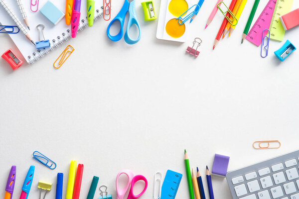 Frame of shcool supplies and keyboard on white background. Back to school, distance learning online concept. Flat lay, top view, overhead.