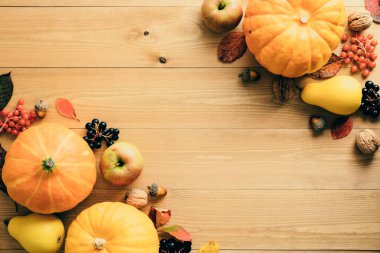 Şükran Günü konseptin kutlu olsun. Olgun turuncu balkabaklarıyla sonbahar kompozisyonu, rustik ahşap masa üzerine düşen yapraklar. Düz konum, üst görünüm, kopyalama alanı.