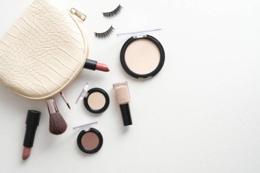 Makyaj çantası, beyaz arka planda kozmetik ve aksesuarlar. Düz yatış, üst görünüm.