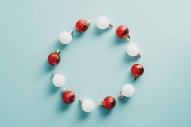 Yeşil arka planda kırmızı ve beyaz toplardan yapılmış klasik Noel çelengi. Düz yerde, üst tarafta. Mutlu Noeller ve yeni yıl konsepti.