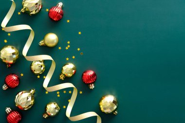 Yeşil arka planda parlak topları ve süslemeleri olan bir Noel çerçevesi. Düz yerde, üst tarafta, tepede. Mutlu yıllar tebrik kartı şablonu, Xmas pankartı tasarımı.