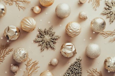 Pastel bej arka planda zarif Noel süslemeleri, düz yatış. Mutlu Noeller ve mutlu yıllar konsepti.