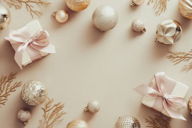 Toplardan yapılmış Noel çerçevesi, hediye kutuları, pastel arka planda Xmas ağacı dalları. Üst Manzara. Düz yatıyordu.