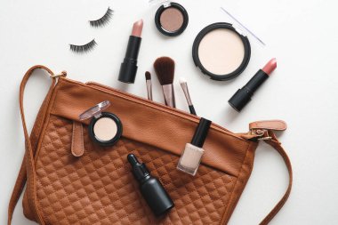 Beyaz arka planda kozmetik güzellik ürünleri olan makyaj çantası. Düz yatış, üst görünüm