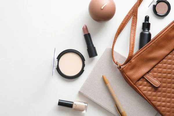 Makyaj ürünleri, makyaj çantası, beyaz masa üstündeki kadın aksesuarları..
