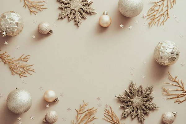 金色の雪片 クリスマスツリーの枝 ベージュの背景のボールを持つクリスマスフレーム フラットレイアウト トップビュー — ストック写真