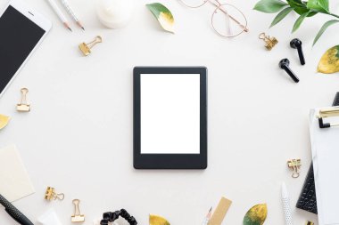 E-kitap okuyucu, e-okuyucu, ofis kırtasiyesi üst görüşlü beyaz masa. Düz yatıyordu.