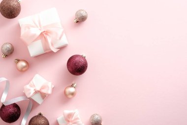 Şık Noel süsleri ve pembe arka planda hediye kutuları. Düz yatış, üst görünüm.