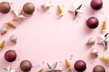 Toplardan, yıldızlardan yapılmış Noel çerçevesi, pembe arka planda süslemeler. Zarif bir Noel tebrik kartı tasarımı. Düz yatış, üst görünüm.