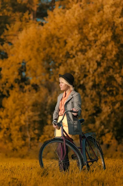 Menina bonita ir para um passeio de bicicleta na floresta de outono — Fotografia de Stock