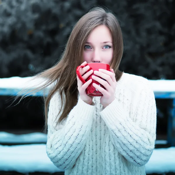 Young beautiful girl drinking tea in a cool winter park — Stock Photo, Image