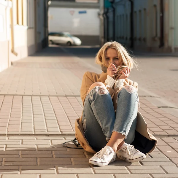 Jovem mulher loira bonita moda vestida de jeans rasgado e suéter branco — Fotografia de Stock