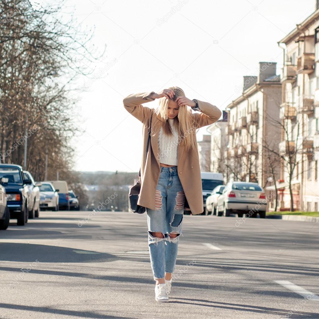 Amazing blonde girl walking alone on the road in old european city ...