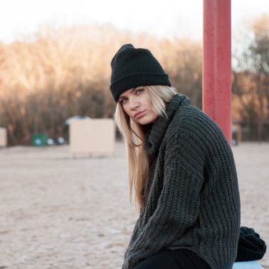 Genç Avrupa kız moda kazak dışarıda güneşli bir sonbahar gününde poz içinde giyinmiş