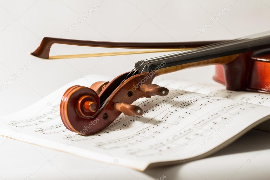 Close up of a violin and bow on book music background