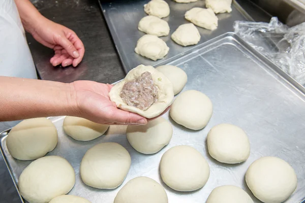 Female hand sculpts buns with meat — Stock Photo, Image