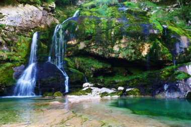 Slovenya 'nın Bovec kentindeki Virje şelalesinin zümrüt renkli suyu. Seyahat, turizm, doğa koruma ve kaynak suyu kavramları