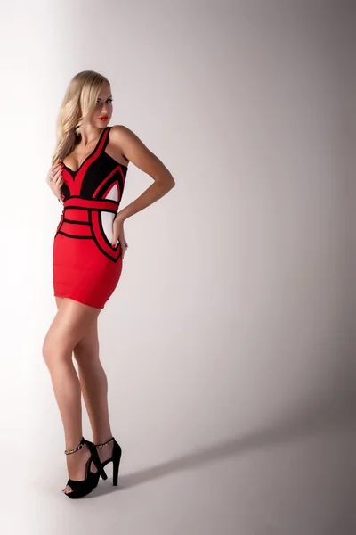 Schöne blonde Frau im roten Kleid — Stockfoto