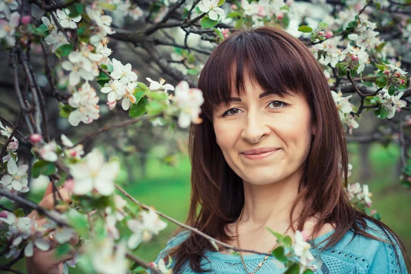 Meisje in de bloemrijke tuin — Stockfoto