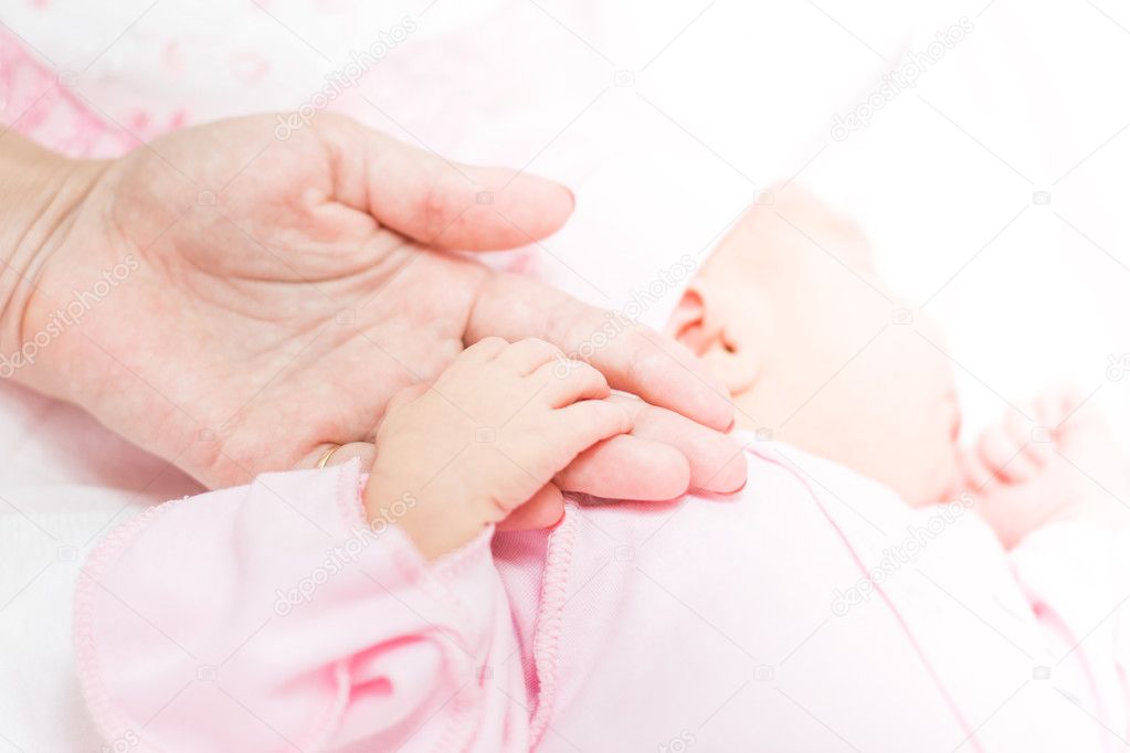 mother holds the hand of a baby