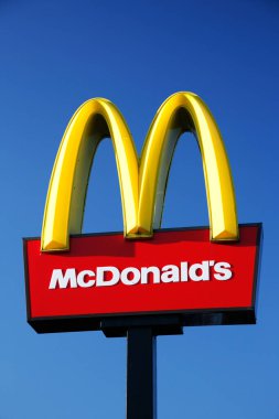 28 Haziran 2012 'de, Londra, İngiltere' de mavi gökyüzü arka planında McDonalds logosu. Dünya çapında her gün 58 milyon müşteriye hizmet veren dünyanın en büyük fast food zinciri.
