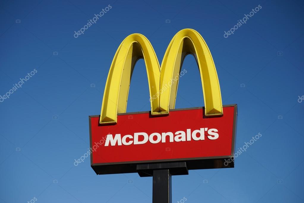 London, UK - December 13, 2014:   McDonalds logo on blue sky background. McDonald's Corporation is the world's largest chain, over 31,000 restaurants worldwide, serve 58 million customers each day, of hamburger fast food restaurants.  More than 10,00