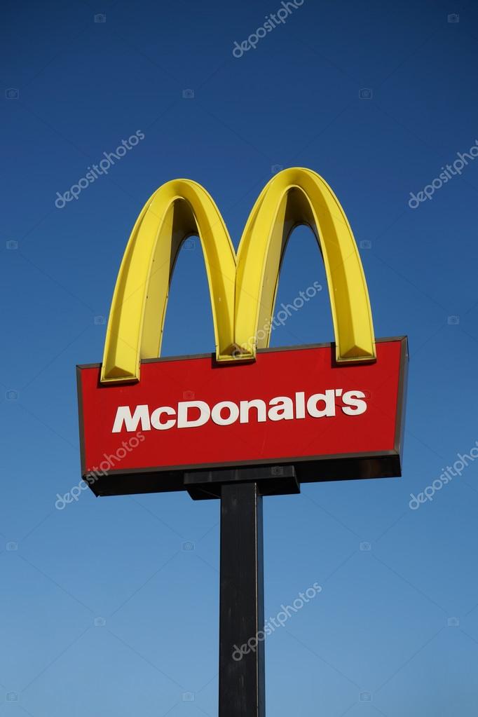 London, UK - December 13, 2014:   McDonalds logo on blue sky background. McDonald's Corporation is the world's largest chain, over 31,000 restaurants worldwide, serve 58 million customers each day, of hamburger fast food restaurants.  More than 10,00