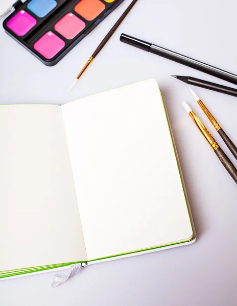 Abra el bloc de notas con páginas en blanco en la mesa con herramientas de oficina —  Fotos de Stock