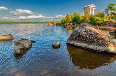 Sıcak bir yaz gününde Monrepos Parkı 'ndaki Neptün Tapınağı. Yürüyüş yolları, Monrepos malikanesi ve aile mezarlığı olan bir müze rezervi. Vyborg, Rusya, Ağustos 2019.