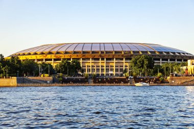 Moskva Nehri 'nin suyundan güneşli bir yaz akşamında Luzhniki Olimpiyat Kompleksi' nin büyük spor arenası. Moskova, Rusya, Temmuz 2021