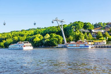 Cabins of the Moscow cable car over pleasure ships and over the Moscow River on a sunny summer day - Moscow, Russia, July 2021