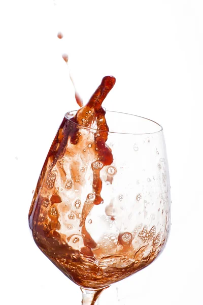 Red wine poured vigorously into a wine glass — Stock Photo, Image