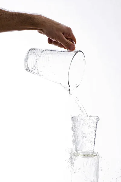 Vierte agua de una jarra en un vaso — Foto de Stock