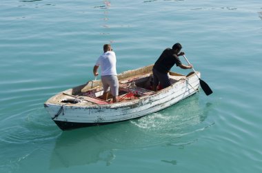 Erkekler satır teknede ters yönde
